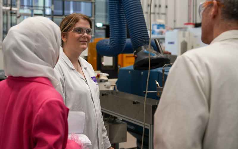 three people in a lab having a discussion