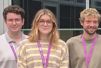 Profiles of three research students stood smiling for the camera.