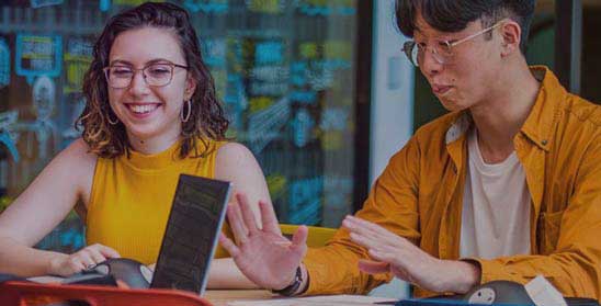 Two students sat talking and smiling